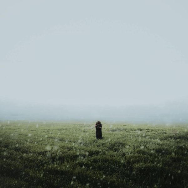 Person meditating in a calm environment with soft golden light.